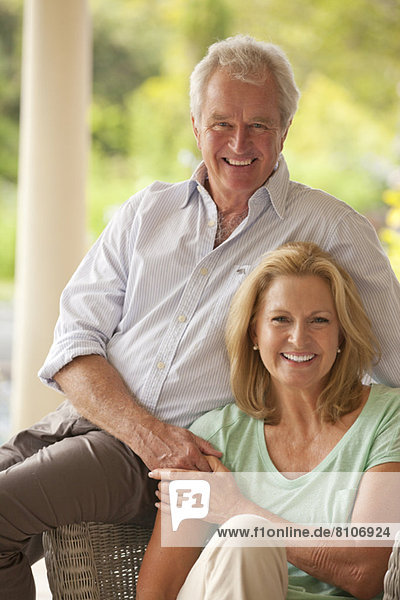 Porträt eines lächelnden Paares  das auf der Terrasse Händchen hält.