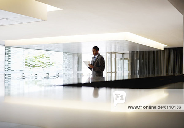Silhouette of businessman with digital tablet in lobby