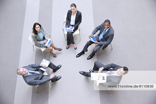 High angle portrait of smiling business people meeting in circle