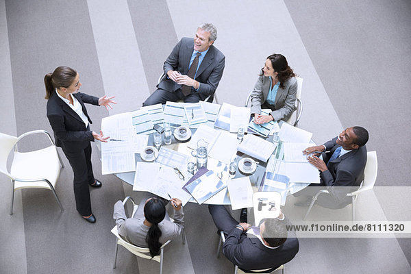 High angle view of gesturing businesswoman leading meeting