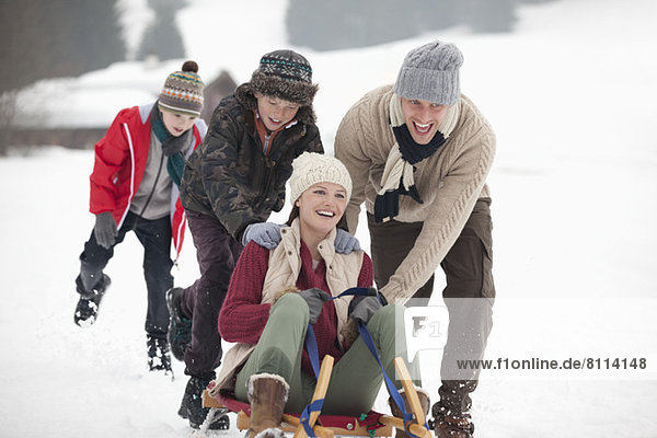 Happy family sledding in snowy field