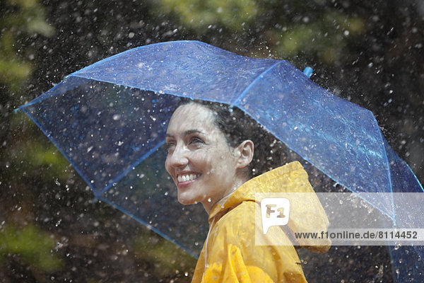 Happy woman with umbrella in rain