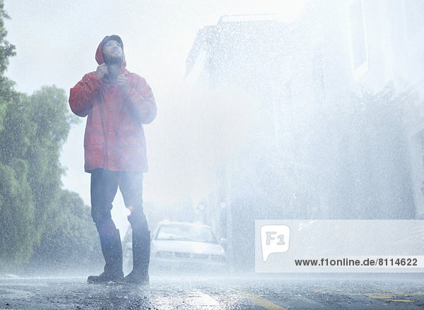 Man wearing raincoat in rainy street