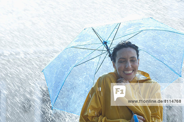 Happy woman under umbrella in rain