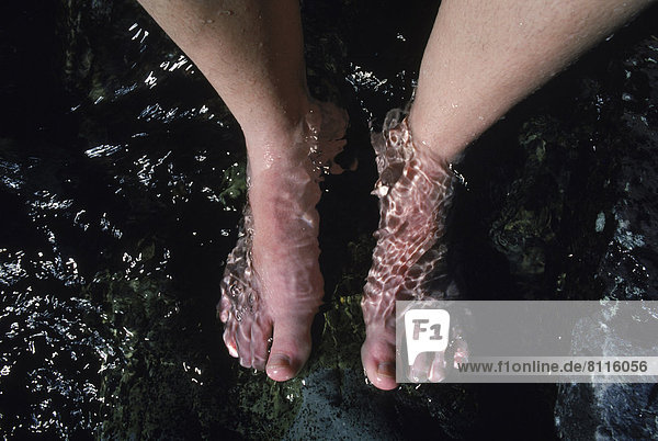 North America USA Montana Water Stream Human Legs Feet Rocks Stones Black One Person Bare Feet Cooling Relaxing Refreshing Tired Wet Cool Soaking Pleasure Outdoors Day Top View Close-Up Horizontal Color Image Photography