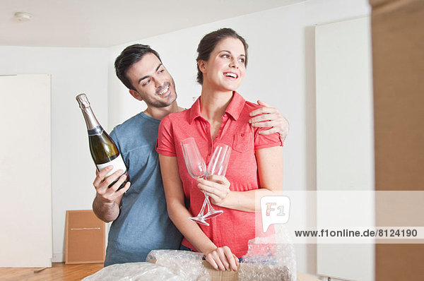 Junges Paar feiert Umzug mit Champagner