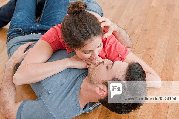 Junges Paar auf Holzboden liegend
