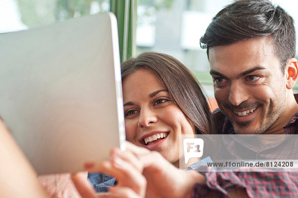 Junges Paar beim Betrachten des digitalen Tabletts