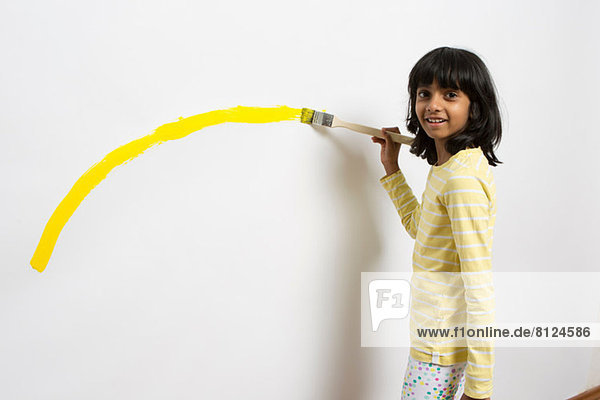 Porträt eines Mädchens mit gelber Kurve an der Wand