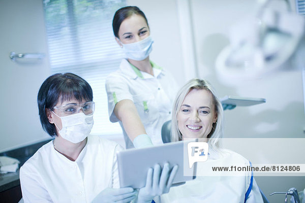 Zahnarzt und Patient beim Betrachten des digitalen Tabletts