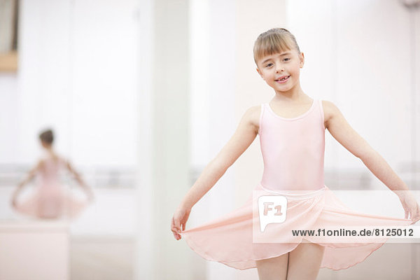 Portrait of a young ballerina holding skirt