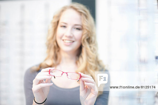 Young woman holding eyeglasses
