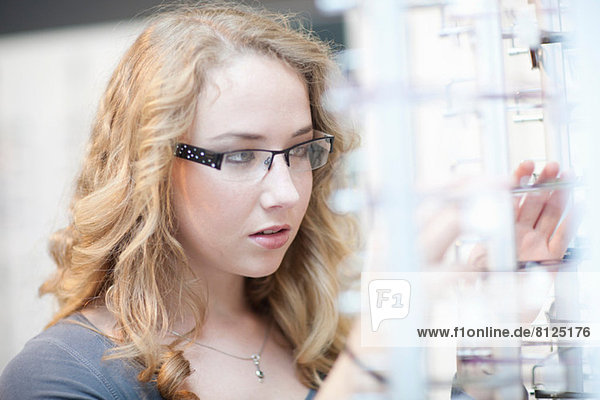 Young woman looking at eyeglasses display