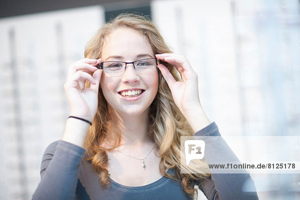 Young woman trying on eyeglasses