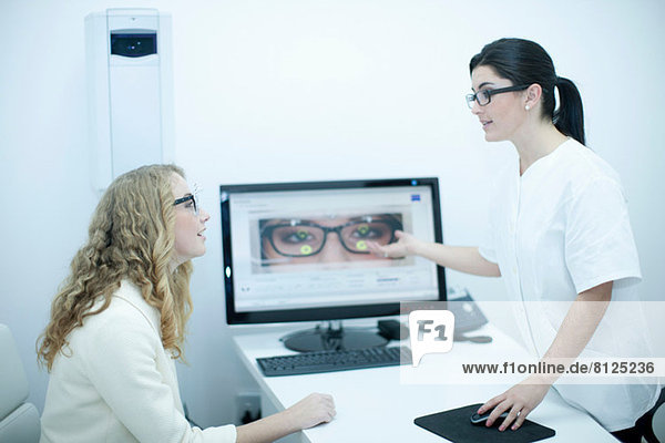 Augenoptiker bei der Auswahl der Brille