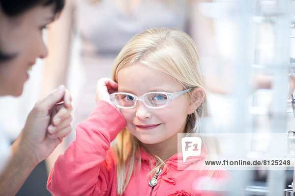 Junges Mädchen bei der Auswahl der Brille