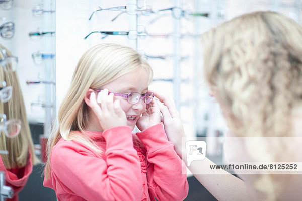 Young girl trying on eyeglasses