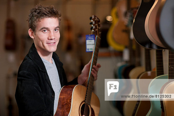 Junger Mann sucht Gitarren im Musikladen