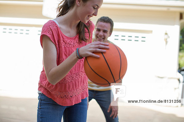 Brother and sister playing basketball