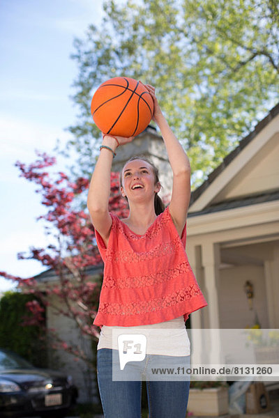 Teenagermädchen hält Basketball über Kopf