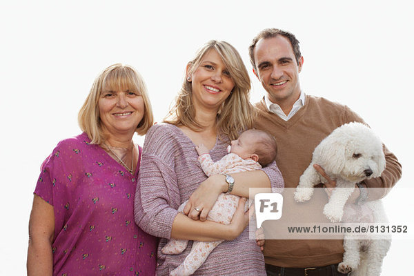 Porträt einer Drei-Generationen-Familie mit neugeborenem Mädchen und Hund