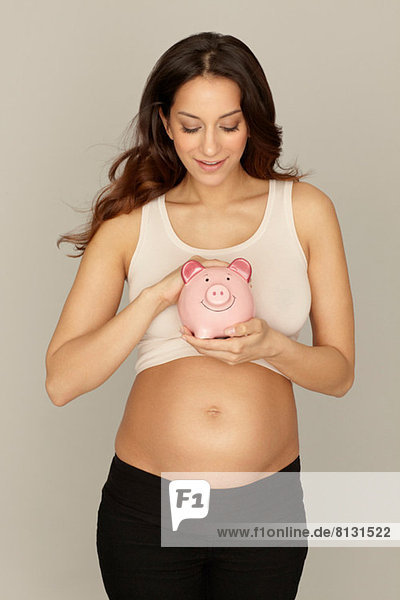 Schwangere Frau mit Sparschwein
