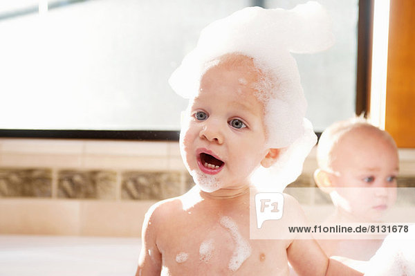 Kleiner Junge mit Seifenlauge im Bad