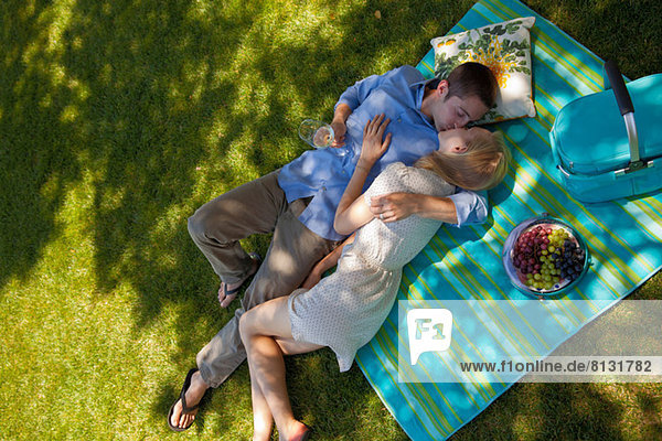 Young couple kissing on picnic blanket  overhead view