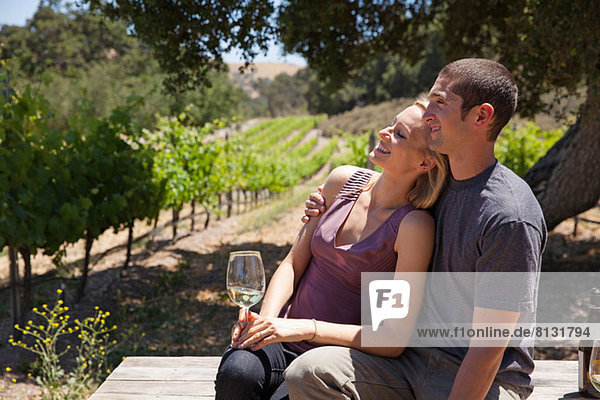 Young couple in vineyard  woman with white wine