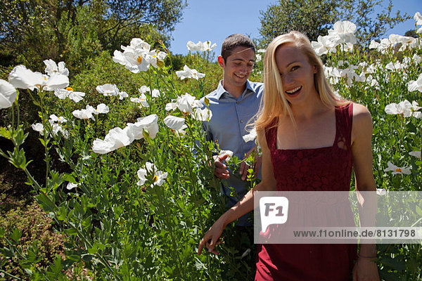 Junges Paar im Feld mit weißen Blüten