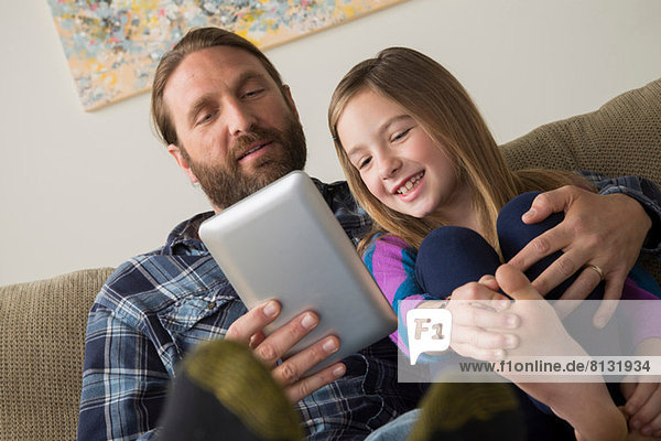 Vater und Tochter beim Betrachten des digitalen Tabletts