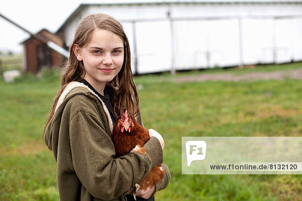 Girl carrying hen