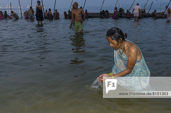 Frau beim Bad am Sangam  dem Zusammenfluss von Ganges  Yamuna und Saraswati  am frühen Morgen  hinduistische Massenwallfahrt  Kumbha Mela