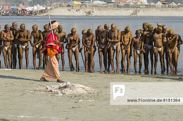 Männergruppe am Ganges erhält Anweisungen von einem Guru als Teil der Initiierung neuer Sadhus  während des Kumbha Mela Festivals