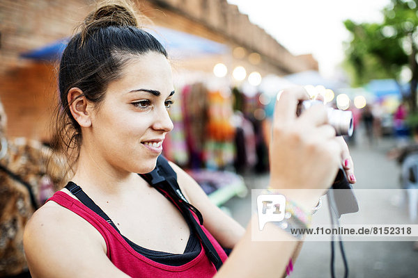 Junge Frau fotografiert auf einem Straßenmarkt