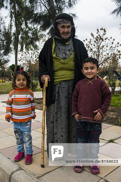 Syrisch-orthodoxe Kurdin mit Tätowierungen auf ihrem Gesicht und ihren Enkeln