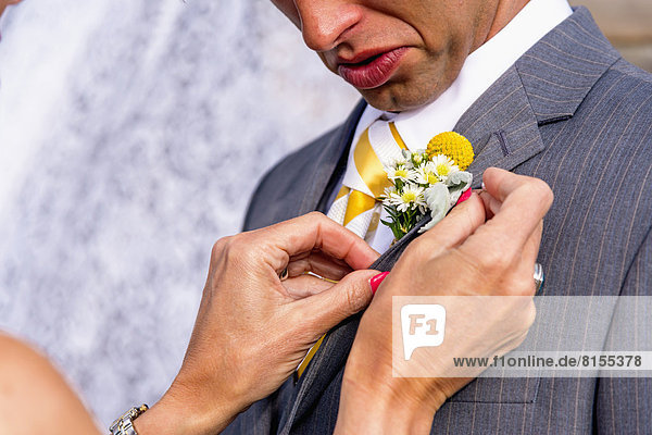 USA  Texas  Future mother in law adjusting boutonniere at grooms suit