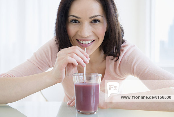 Caucasian woman drinking purple smoothie