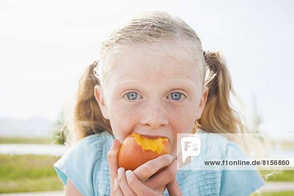 Außenaufnahme  Europäer  Frucht  essen  essend  isst  Mädchen  freie Natur