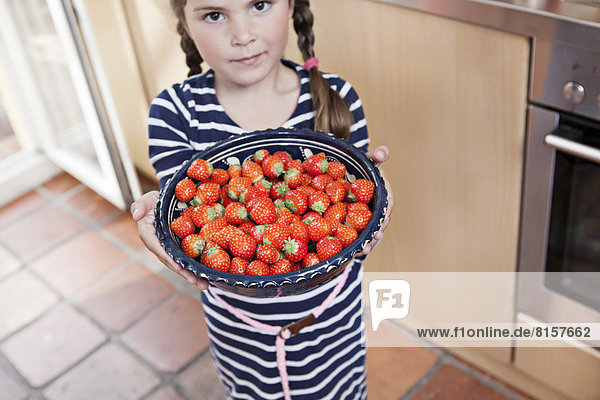 Deutschland  Nordrhein-Westfalen    Porträt eines Mädchens mit Erdbeerenschale