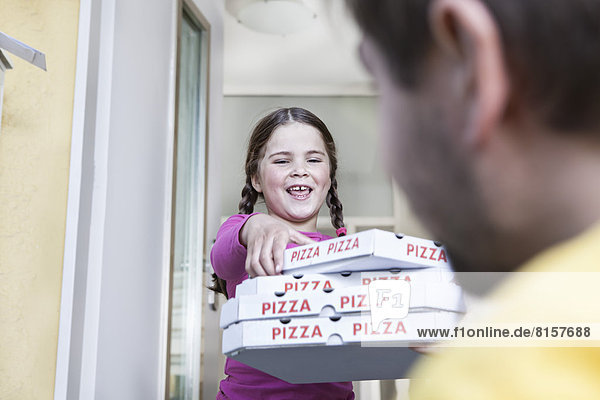 Deutschland  Nordrhein-Westfalen  Köln  Mädchen nimmt Pizzakartons vom Zusteller  lächelnd