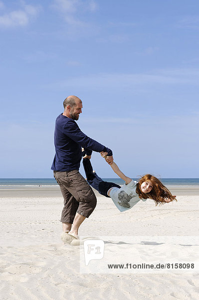 France  Father with daughter having fun at beach