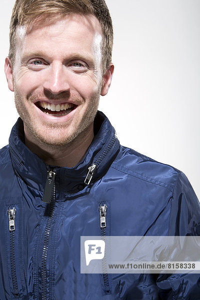 Portrait of mid adult man in blue jacket smiling  close up