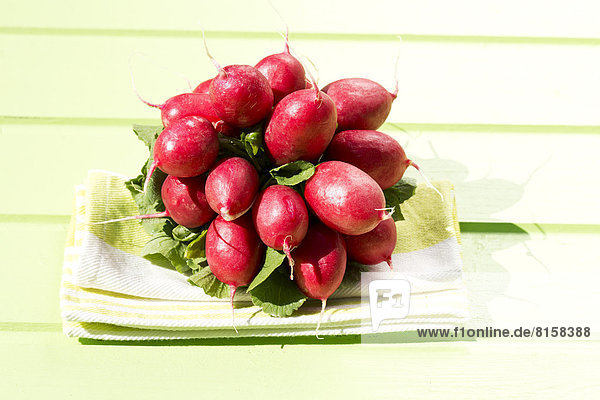 Bunch of red radishes on wooden table,  close up