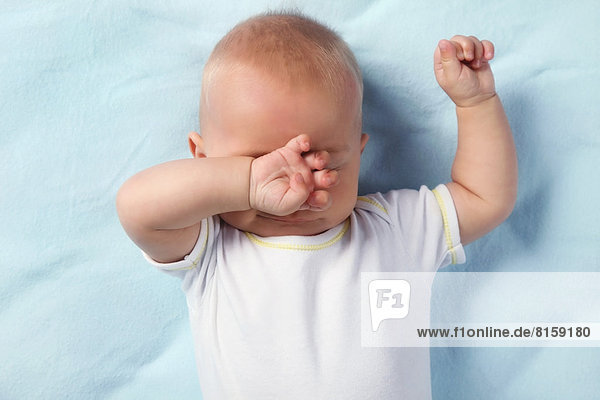 Baby Junge reibt sich die Augen.