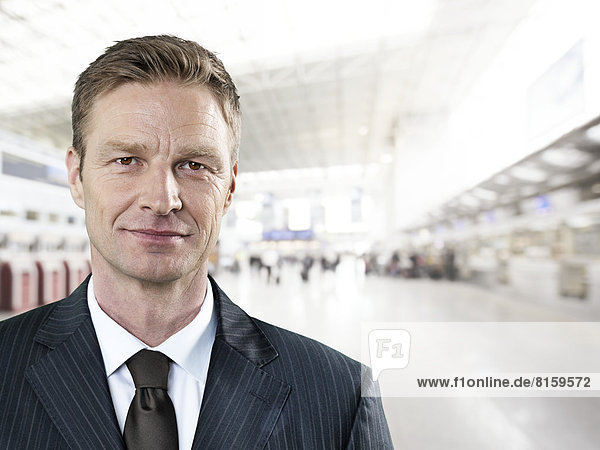 Porträt eines Geschäftsmannes am Flughafen  lächelnd