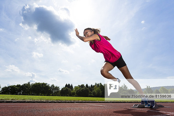 Deutschland  Junge Frau beim Sprintstart