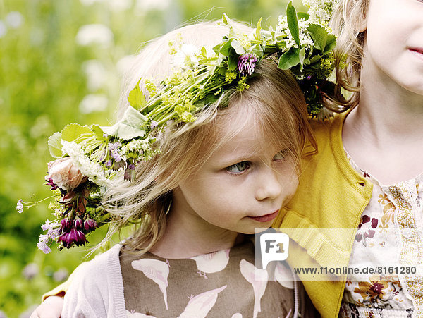 Girl wearing flower wreath with mother