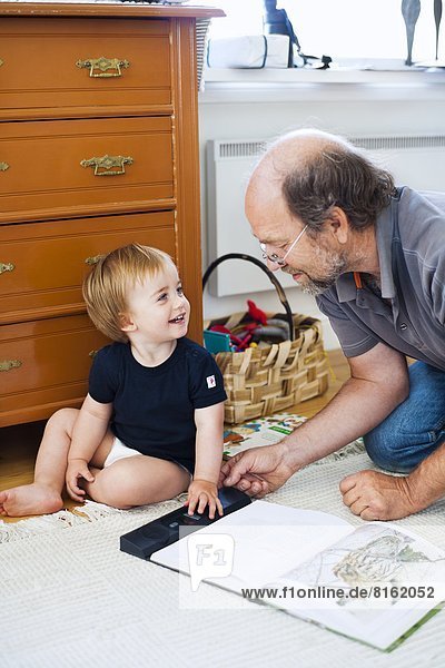 Grandfather with grandson reading book