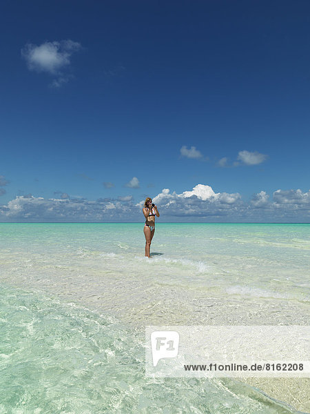 Woman taking photos on tropical beach